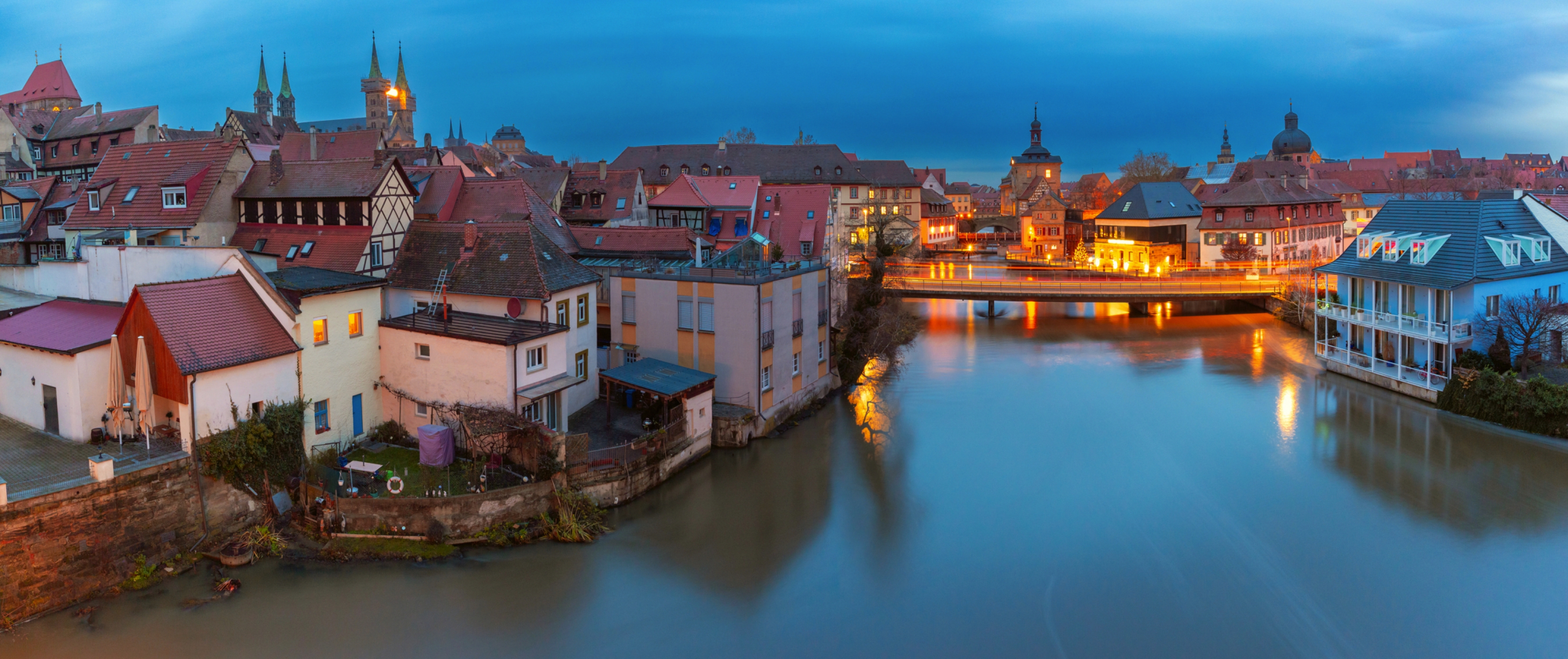 Luftpanorama der Altstadt und der Regnitz bei Nacht in Bamberg